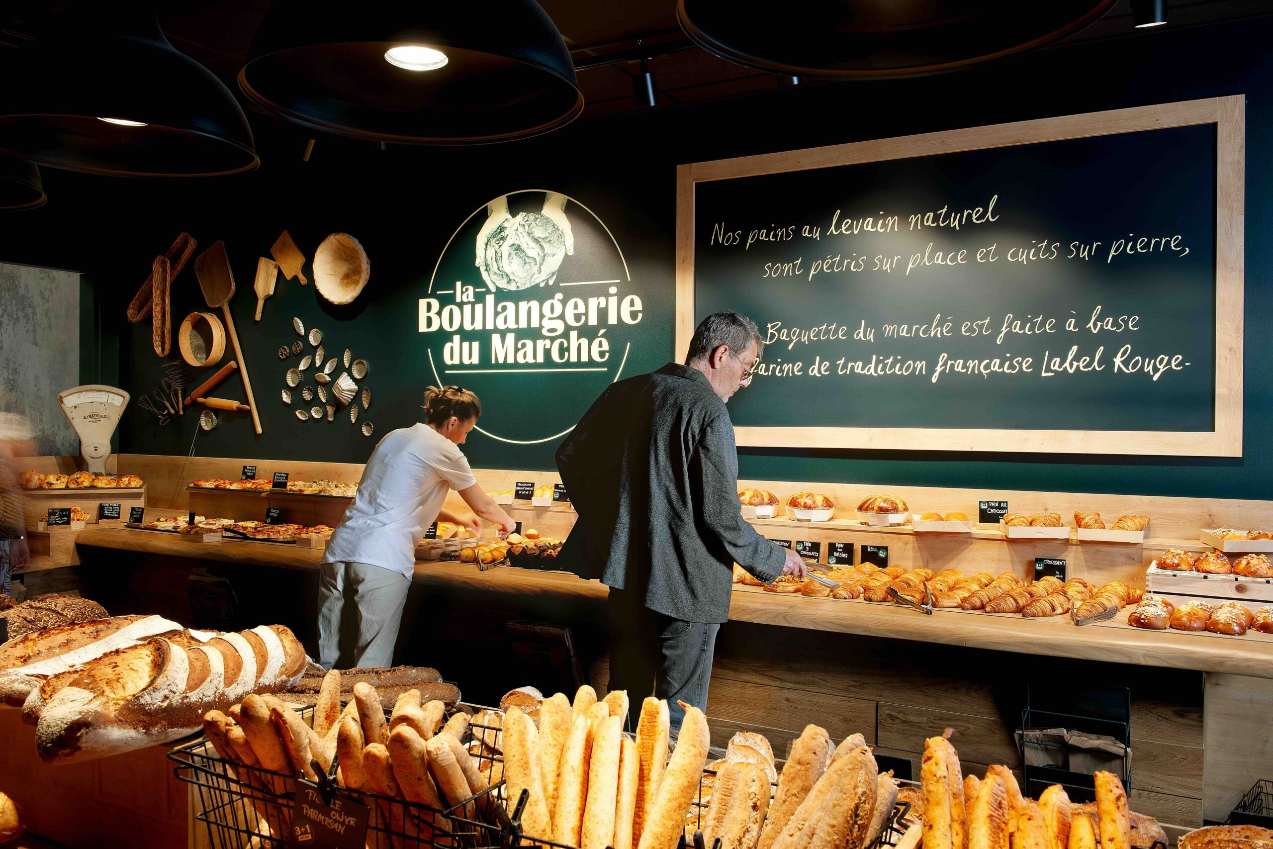Clients choisissant des pains et viennoiseries à la Boulangerie du Marché.